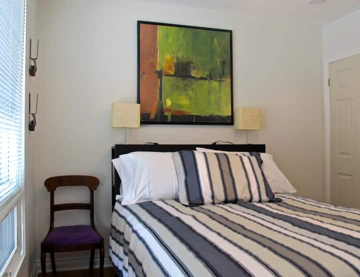 The South bedroom has a double bed, looking out over the front lawn and the parks beyond.