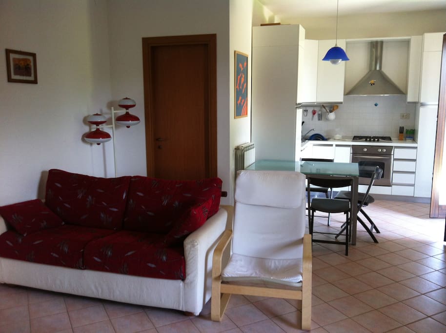 The living room with the kitchen area in the background