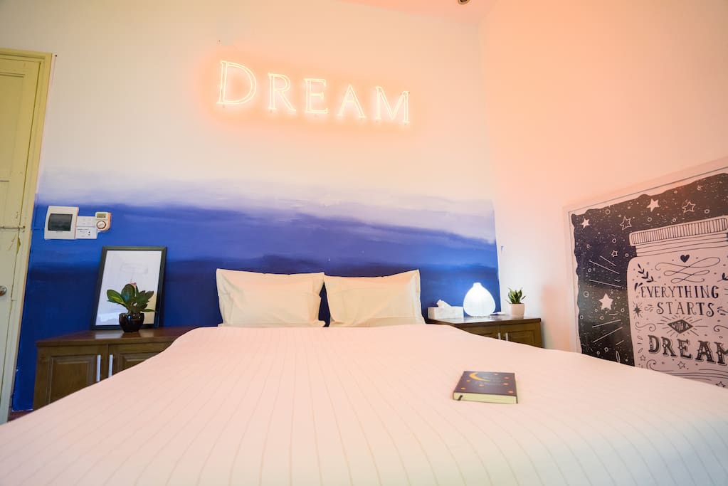 Dreamy bed featuring original neon sign