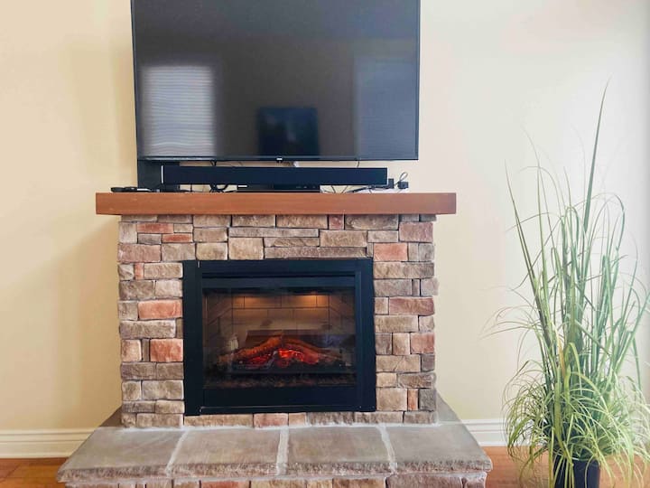 Large flat screen TV with cable and warm electric fireplace bring a cozy feeling to this living space 