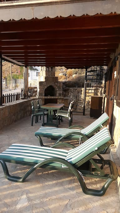 Covered terrace with stone BBQ. Views across the bay.