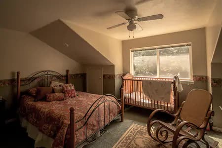 Spálňa na poschodí (1/3) s dvoma kubami, detskou postieľkou a vchodom do kúpeľne. Manželská posteľ.
