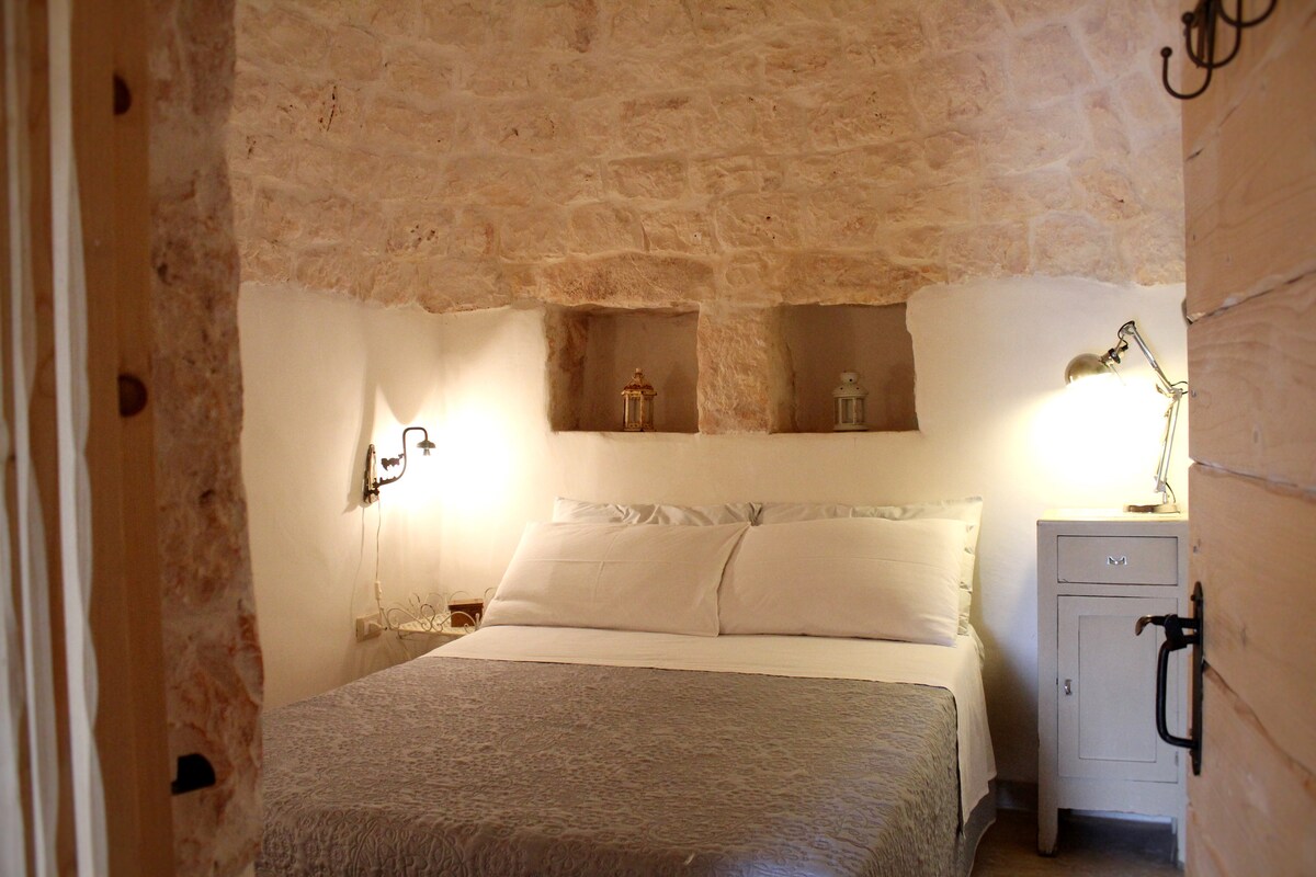 The first double bedroom inside the trullo with a French bed
