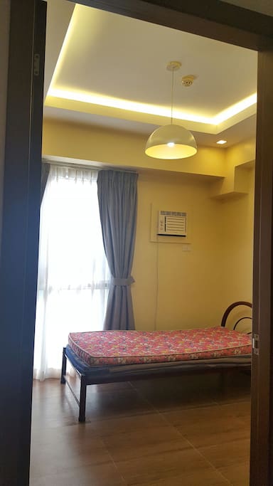 Second bedroom with cove lighting and air conditioner