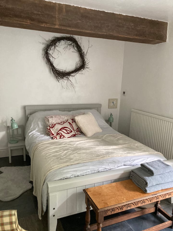 Large bedroom with double bed and single bed, with door out to garden