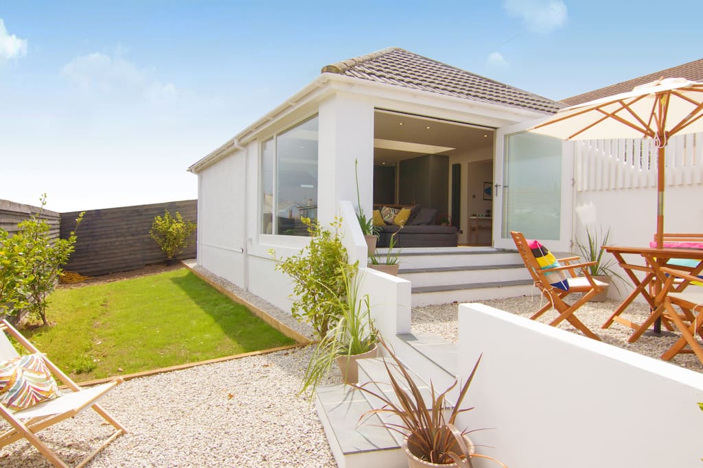 private sun terrace with lawn and seating area looking towards estury.