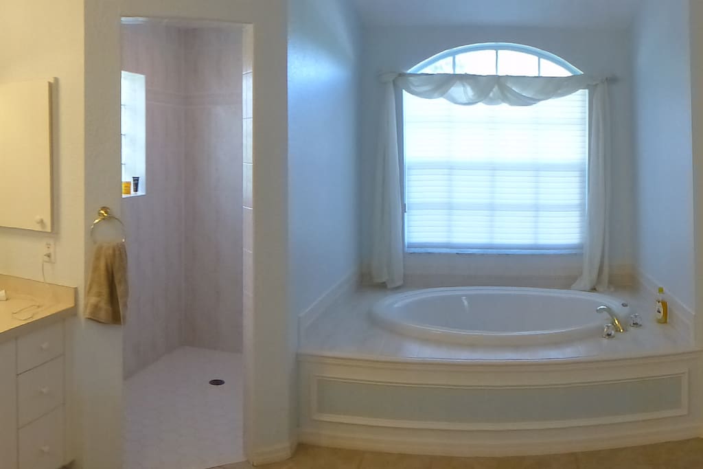Master bathroom with roman shower, twin vanity units and separate toilet.
