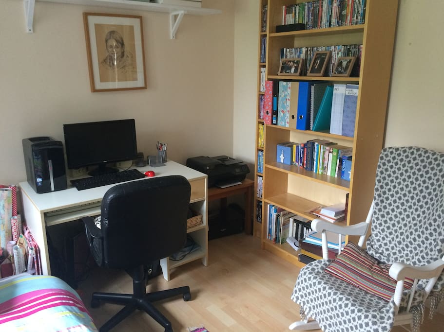 Writing desk with a computer. Selection of books and DVDs.