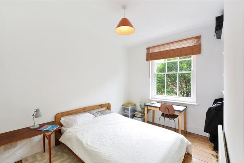 Bright, clean, white bedroom with storage space and a desk to work