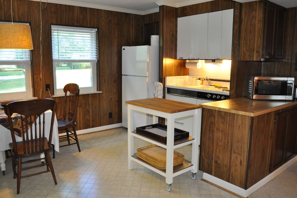 Kitchenette has bar sink next to a 3 burner stove, small oven, full-size refriderator, microwave and toaster.