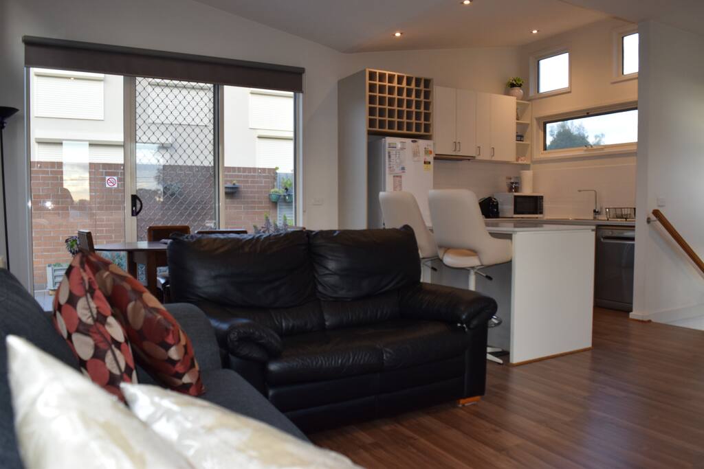 Living and meals area, leading to modern kitchen (upstairs). Island bench ideal laptop-friendly workspace.
