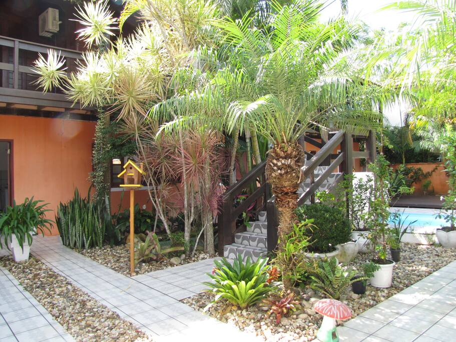 Jardim, piscina e escada de acesso ao apartamento.