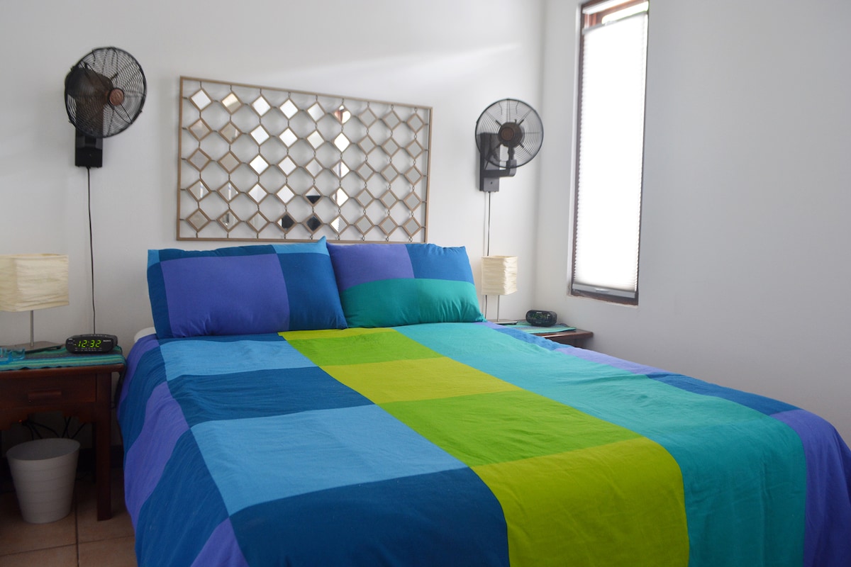 חדר שינה ראשי עם מיטת קווין סייז וחדר רחצה צמוד