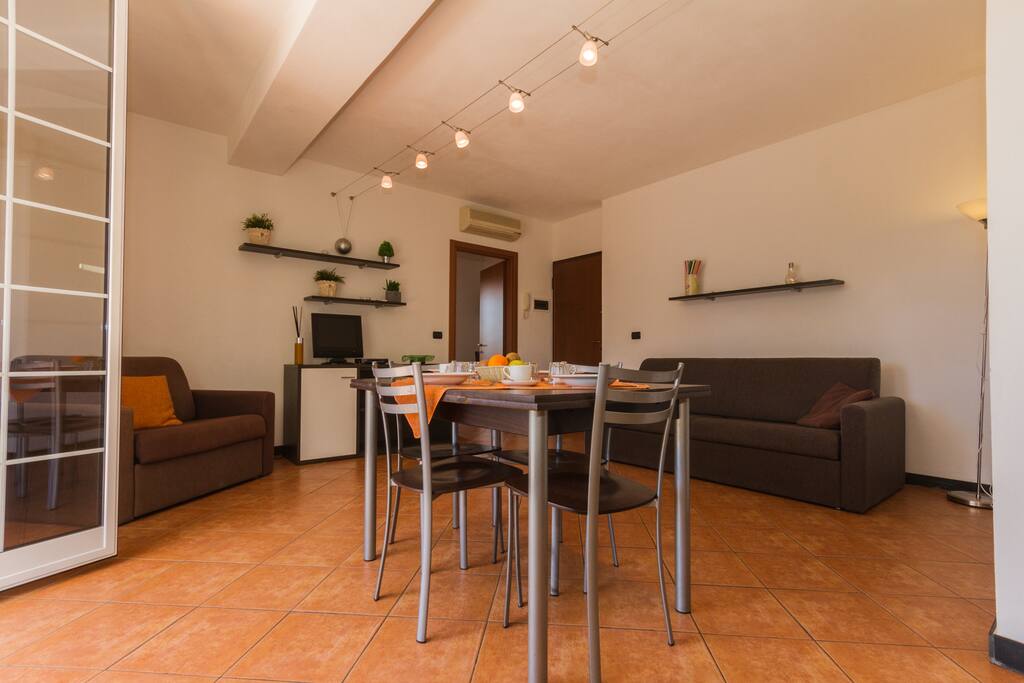 Kitchen and living room with flat screen TV dining table and sofa