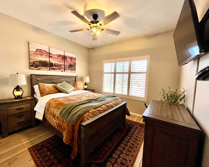 Chambre queen size (illustrée avec courtepointe en option) avec placard, porte-bagages et télévision