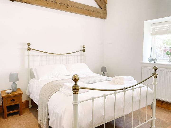 King size bed in downstairs bedroom with en-suite shower room. 