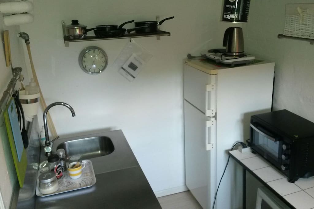 Small kitchen including frigde and freezer, mini stove, microwave, kettle etc.