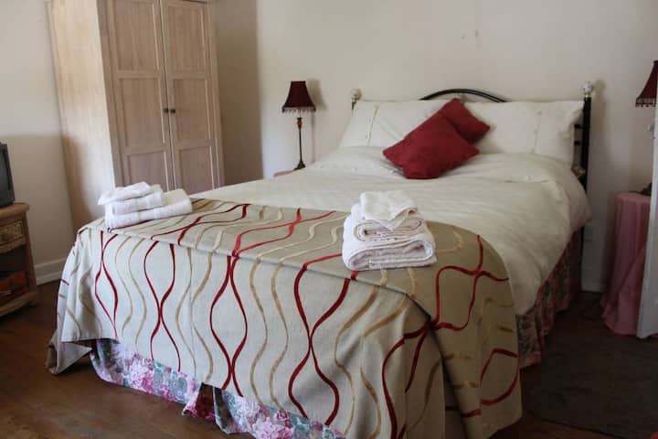 Master double bedroom has Oak panelled floor, large double bed and feature windows