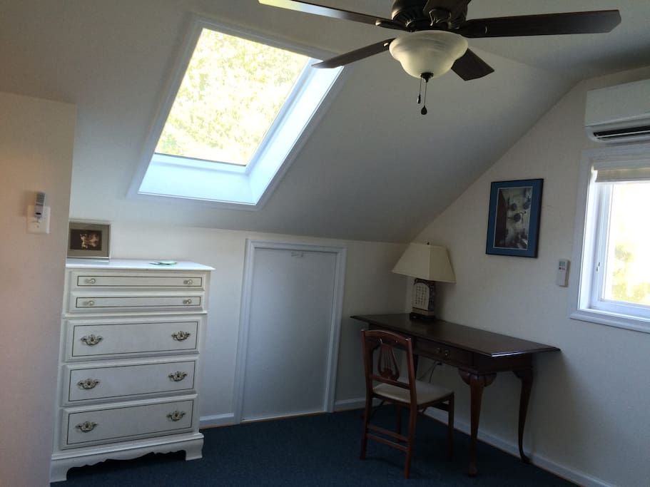 Skylight, desk, dresser and ceiling fan.