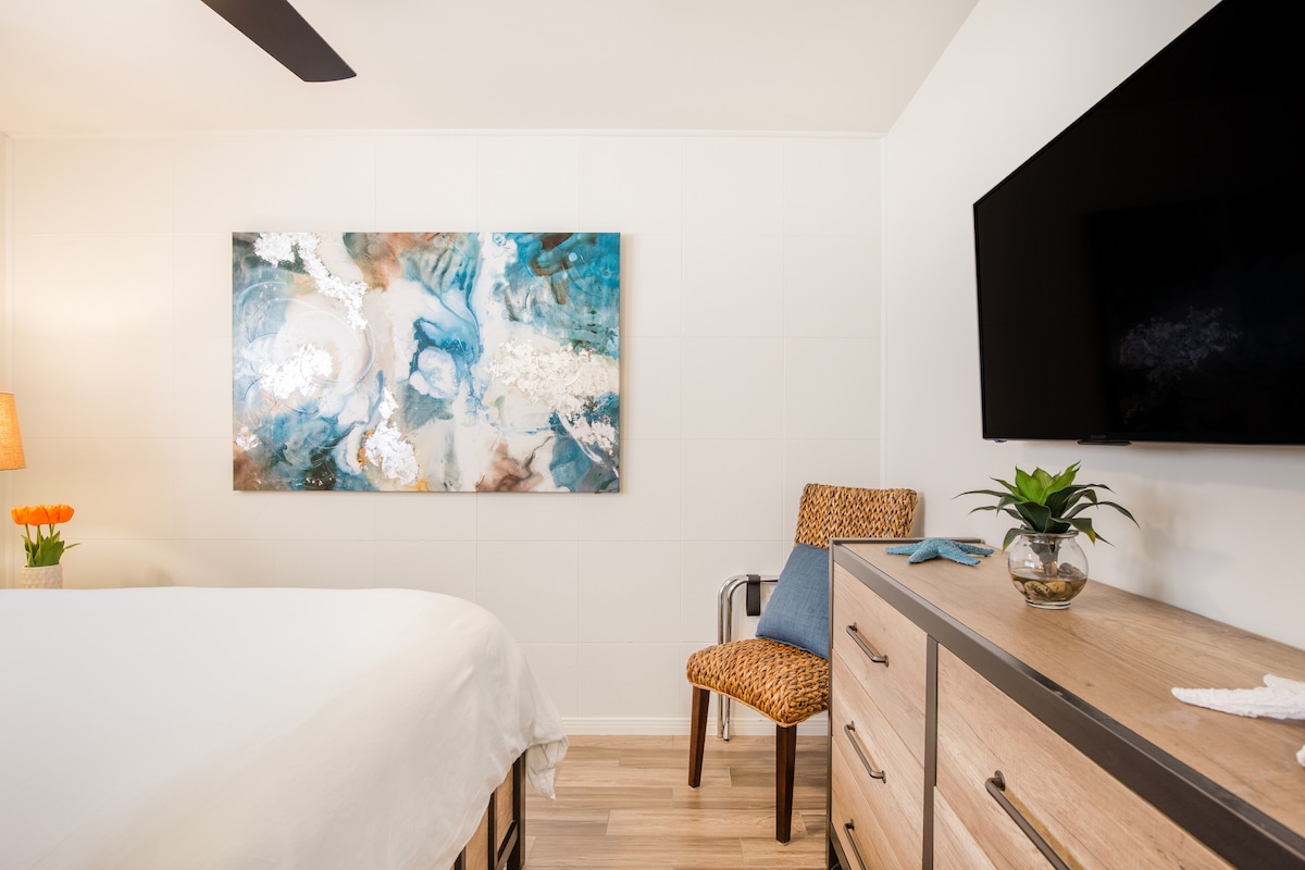 A peaceful retreat with large bed, modern design, ample closet, TV, and beautiful natural light from the large window.