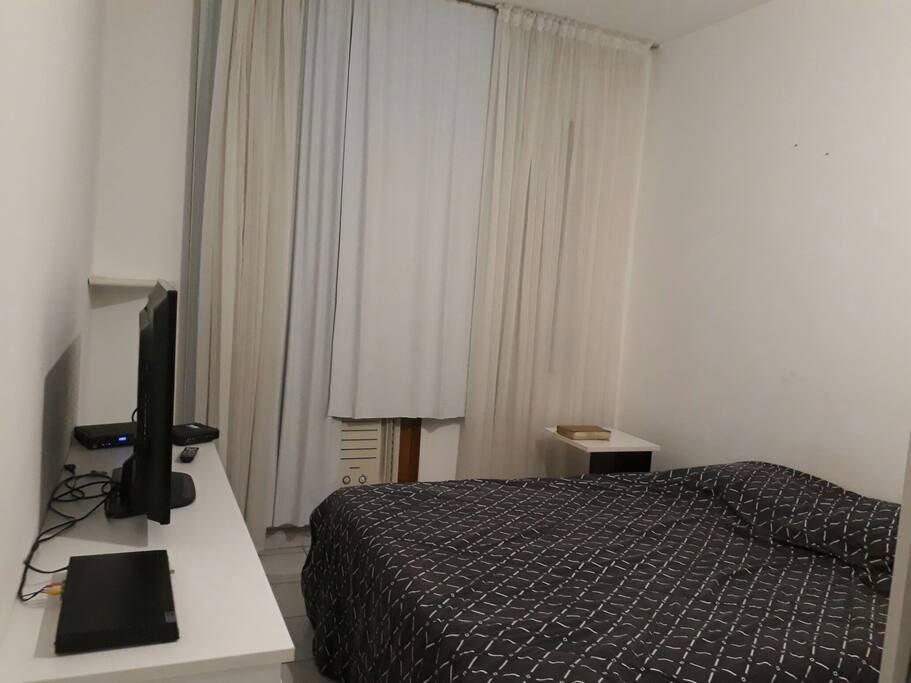 um quarto com cama, ar e televisão