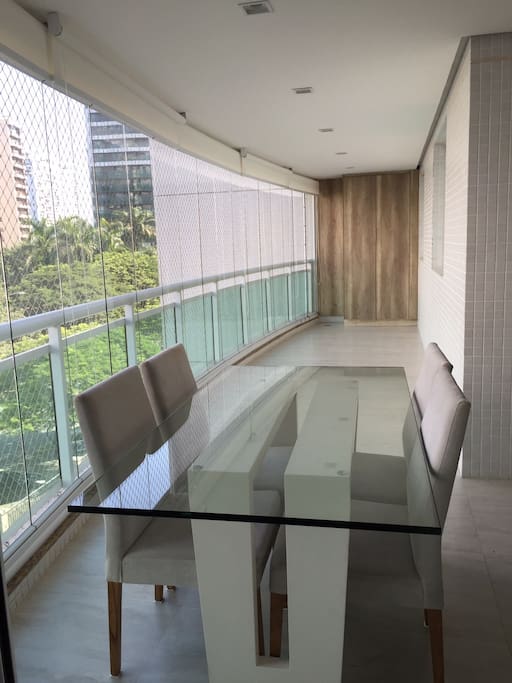 Varanda ampla em mármore Travertino, com vista para Parque da Península e lagoa.