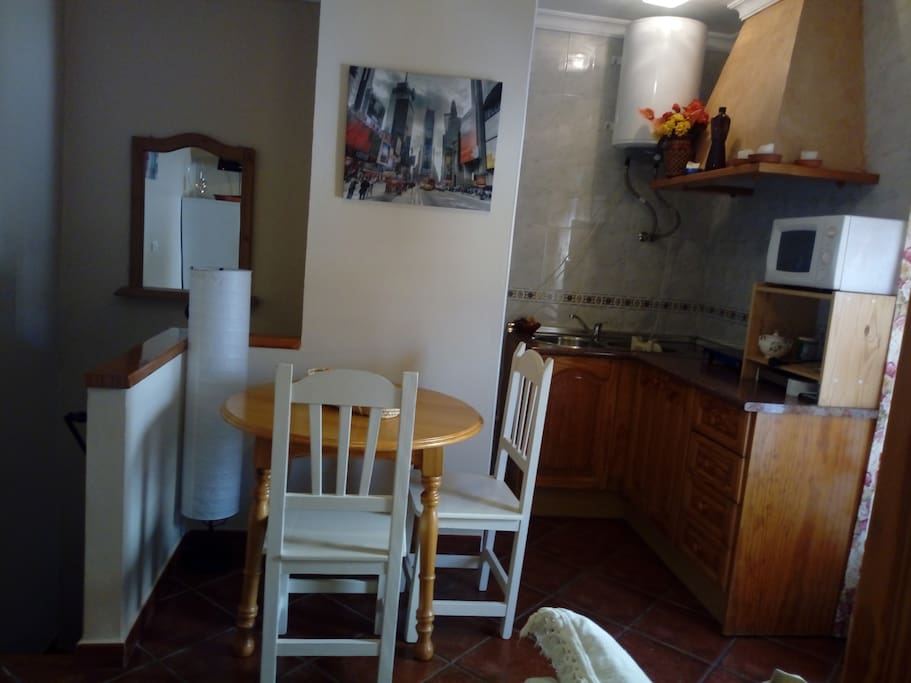 Zona de comedor y cocina al fondo.