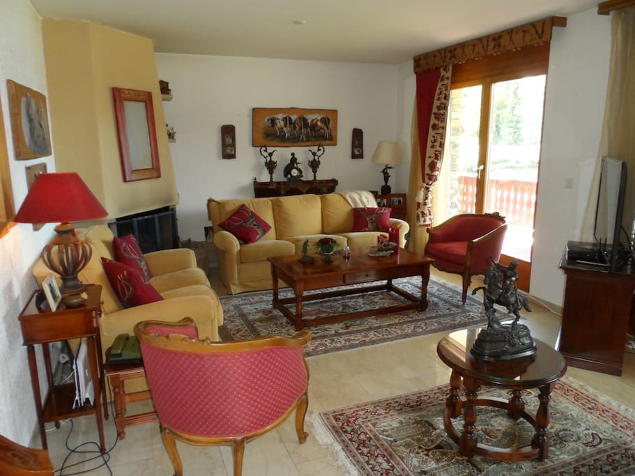 The living room with fireplace and access to a large balcony