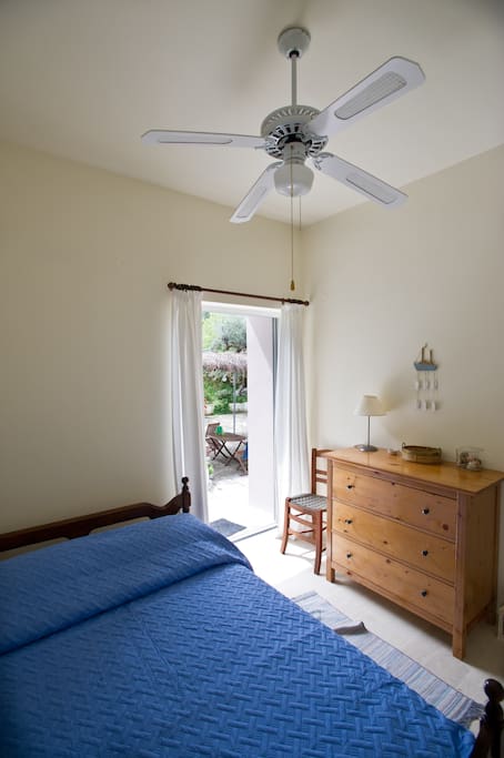 Main bedroom with double bed and access to the yard. There is also a roof fan