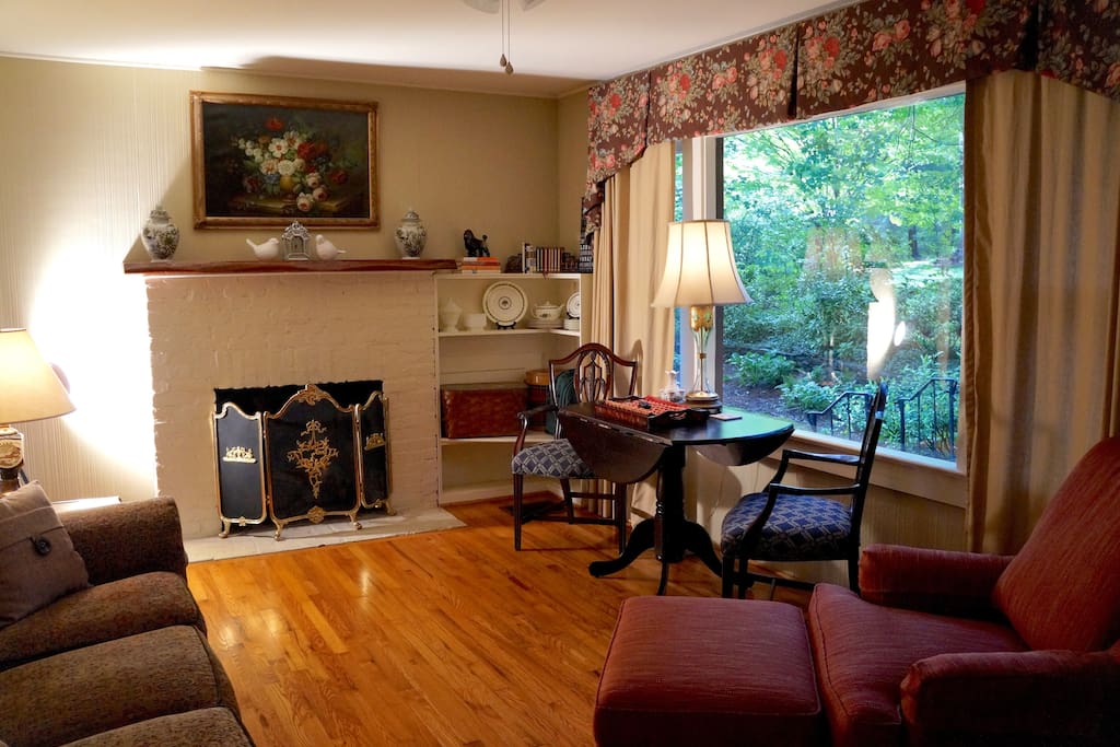 Open plan living room with gas log fireplace, private garden view