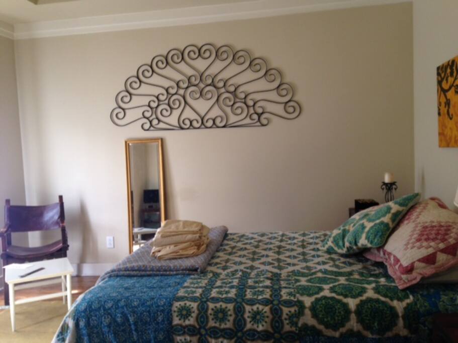 Master ensuite bedroom. Features pair of Juliet balconies, a pair of closets, small flat screen, queen bed.