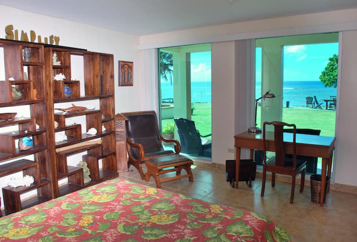  Profitez d'une vue directe sur l'océan et le coucher du soleil depuis le salon en bas de la suite Coral.  Cette chambre d'entrée dispose d'un canapé/lit pliant, d'un bureau d'écrivain classique et d'une décoration de meubles unique.