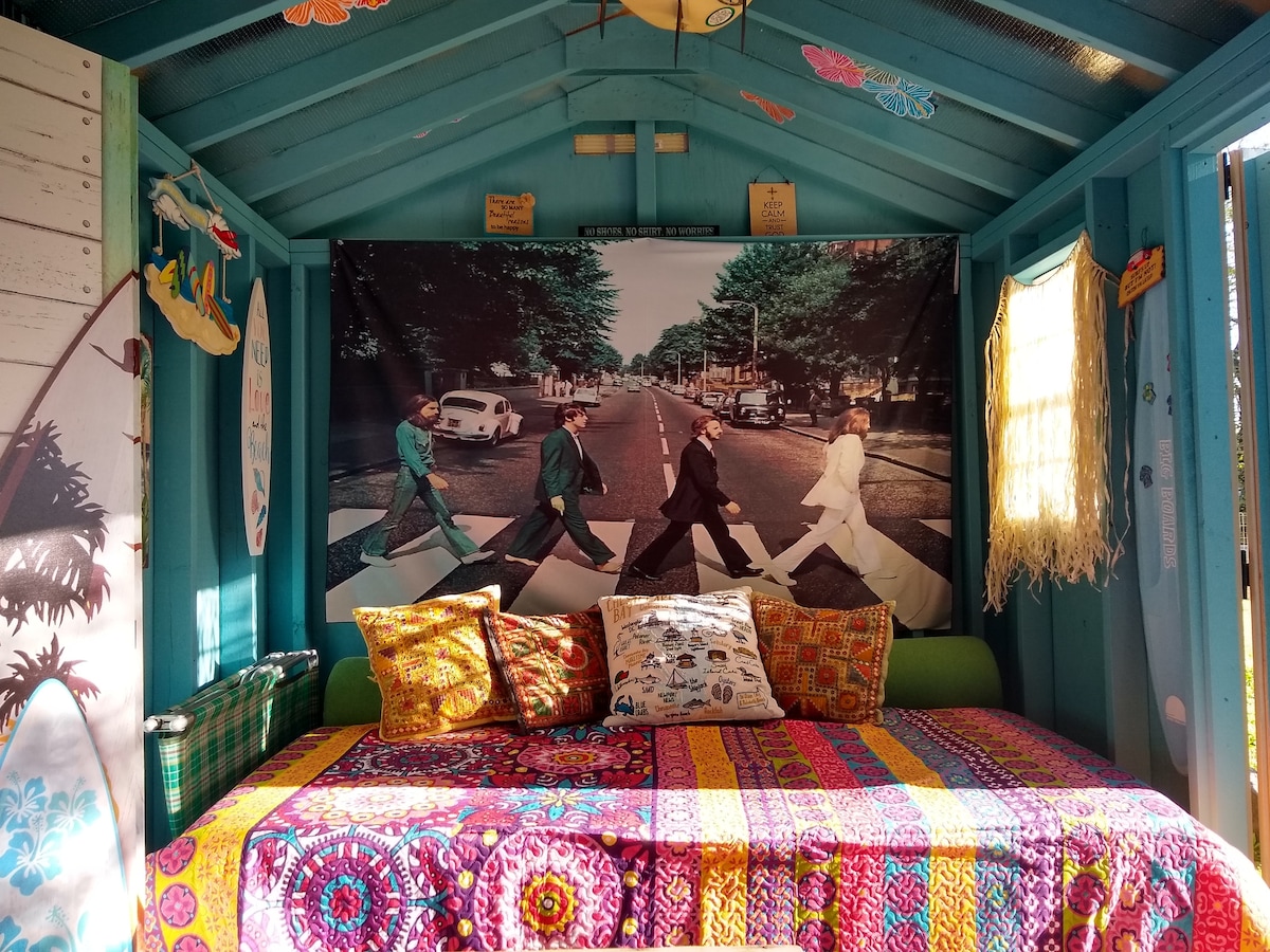 Tämä on Surf Shackin oikea puoli. Täysikokoinen futon ja vintage-taitettava vauvansänky Beatlesilla tervehtimässä sinua joka aamu.