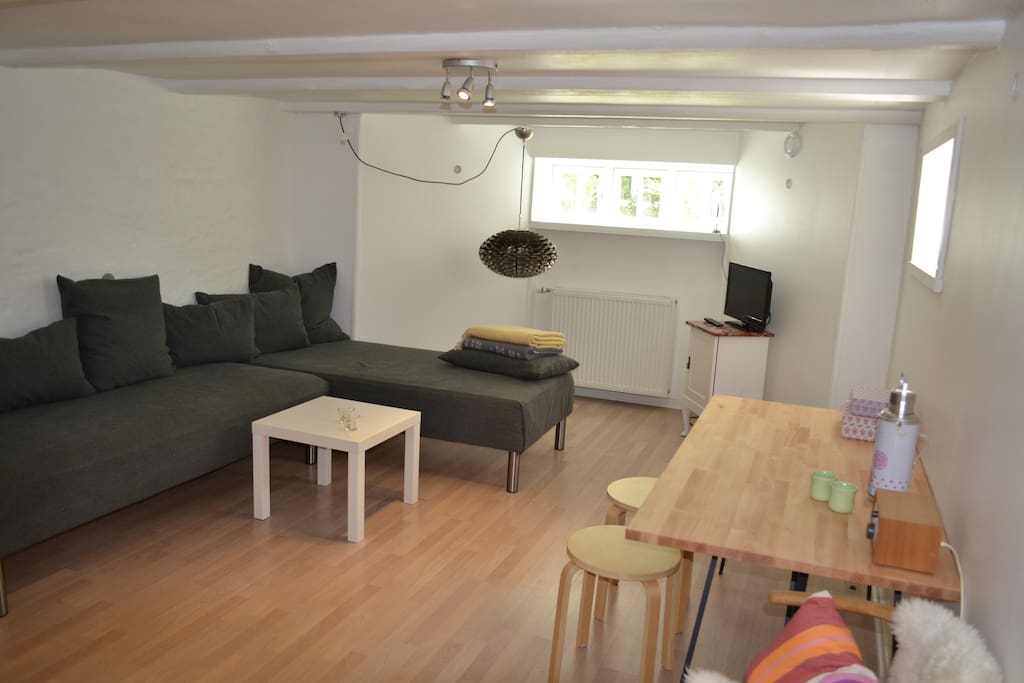 Living room with dining table. The sofa also serves as two beds. For the big family there is a mattress on the floor.