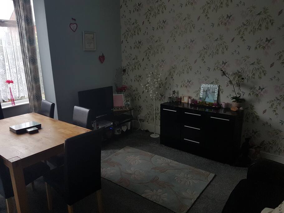Dining/middle room. There is a sofa bed in here, a dining room table a smart tv.