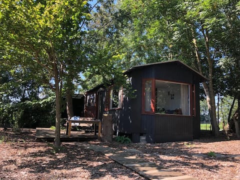 Tiny House surrounded by water with Rowing Boat