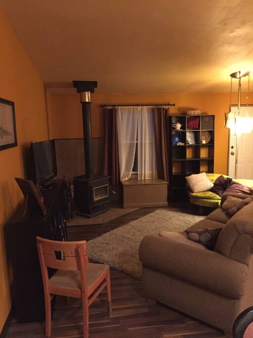 Another picture of the living room showing the front door and more seating.