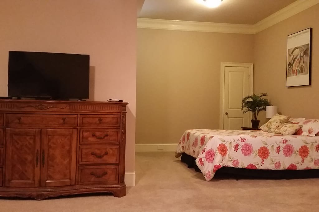 HDTV, queen bed and dresser of drawers. HDTV comes with movie channels and full spectrum of cable TV.