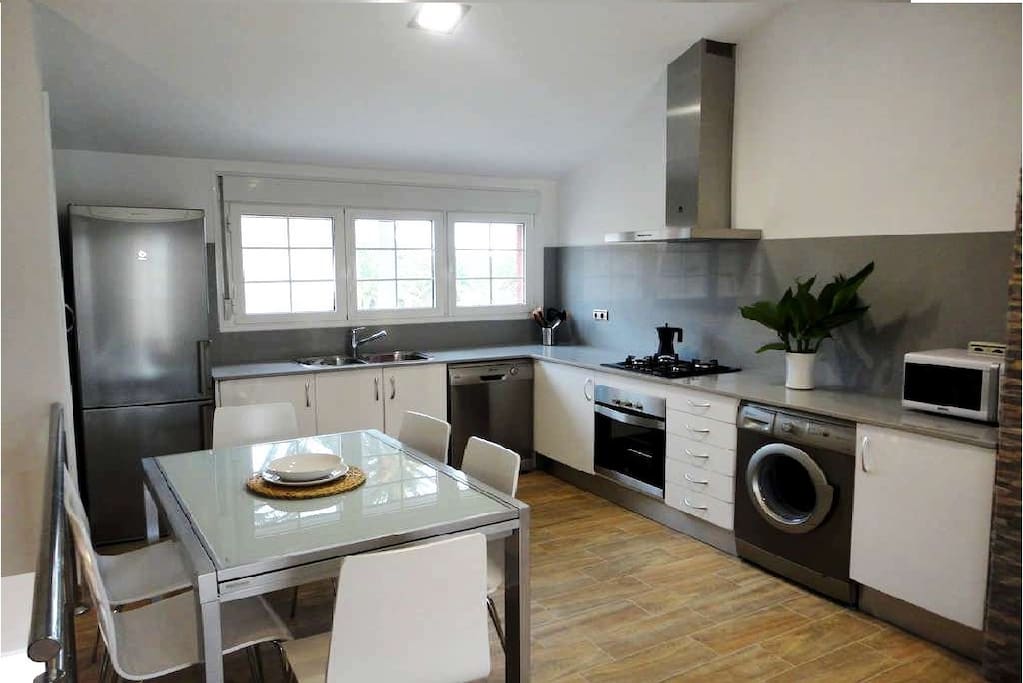 Moderna cocina equipada y comedor con mucha luz