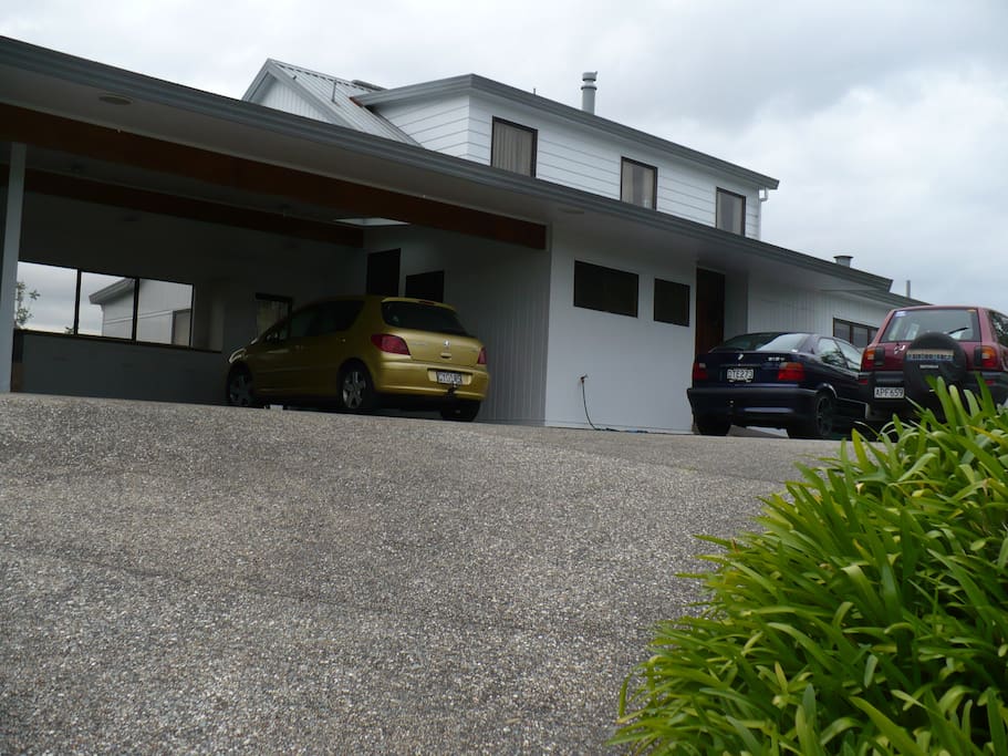 View from the road of house with double carport and outdoor parking.