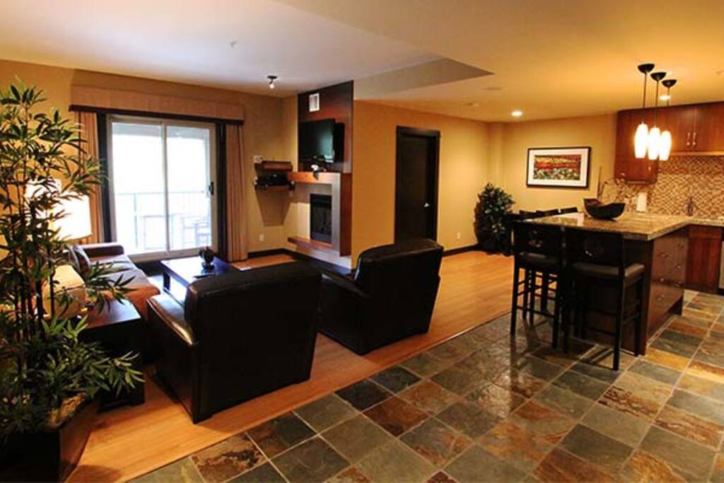 Stunning open concept living area with a welcoming fireplace to warm up with