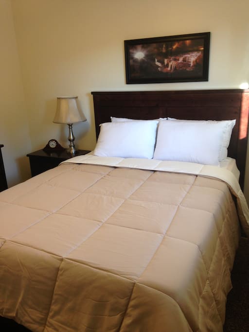 Bedroom with comfortable queen bed, night stand and dresser