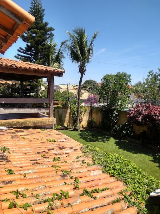 Vista da janela do quarto para o jardim lateral da casa