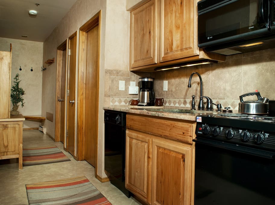 The fully-equipped kitchen features a natural wood finish