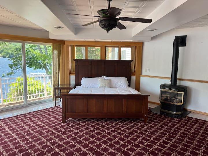 Спалня с двойно легло в осмоъгълна стая с красива гледка към езерото. Газова камина и телевизор. 