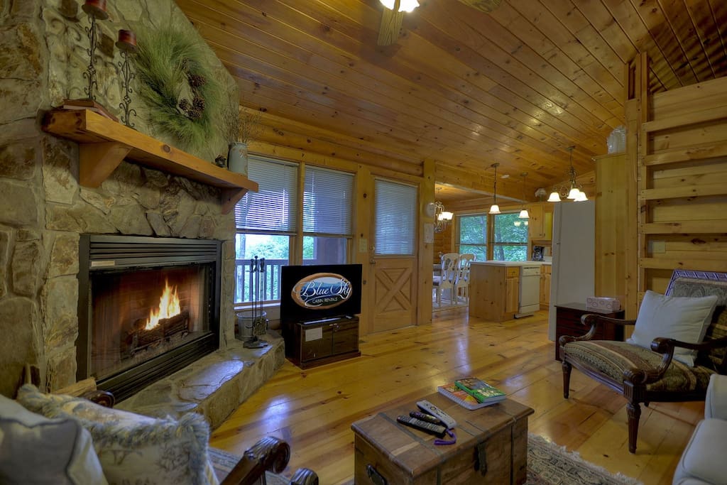 beautiful great room with flat screen TV and stone, wood burning fireplace