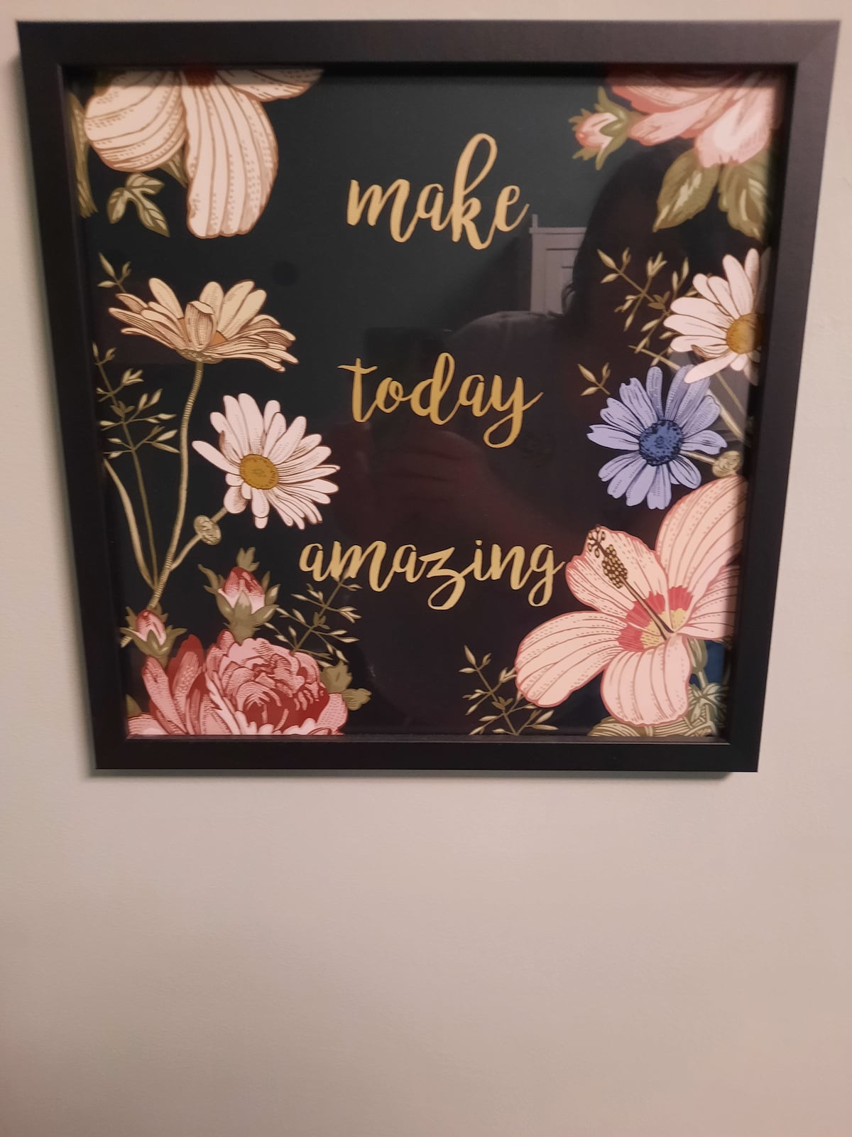 A framed artwork featuring floral designs in various colors surrounds the phrase 'make today amazing.' The colors include soft pastels and bold shades, with a black background creating contrast against the vibrant flowers.