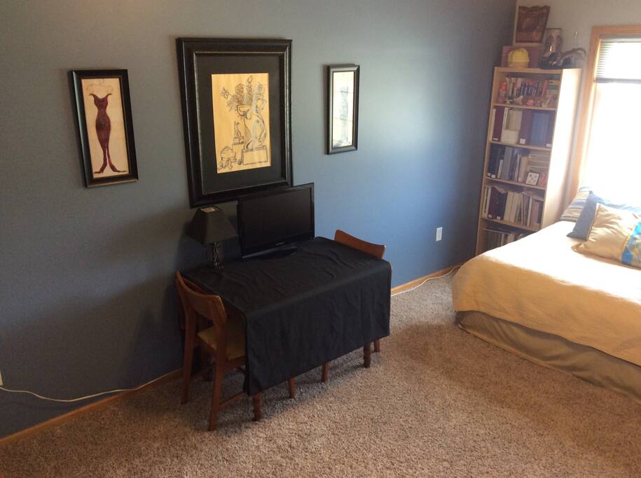 Table for computer (side swings up for larger surface area). Lamp. (Fan not pictured.) The TV has a built-in DVD player on the side. A channel guide is in the room.