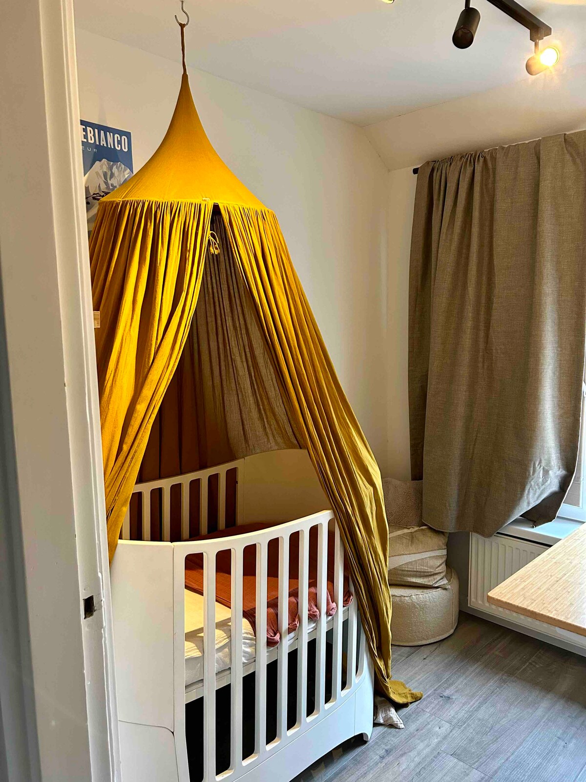 ในการศึกษาถัดจากโต๊ะทำงานในห้องโดยสารมีเตียงเด็กอ่อนพร้อมสวรรค์พร้อมม่านบังแสงด้านหน้าหน้าต่าง