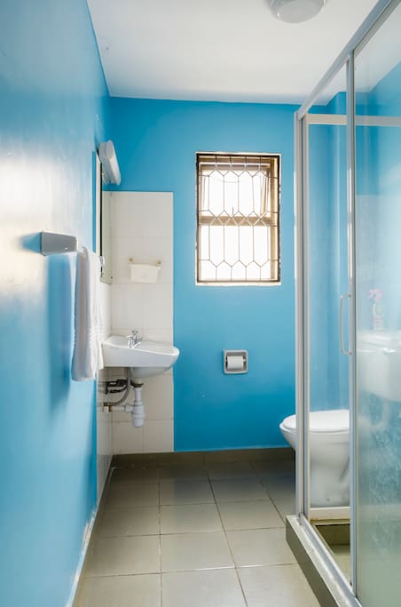 Spotlessly clean & bright washroom with hot water shower cubicle